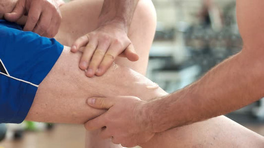 A small jar of joint pain ointment placed on a wooden surface, with a hand applying the ointment to a sore knee. The setting conveys a sense of relief and care, focusing on the ointment as a solution for joint pain.