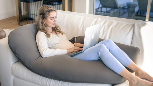 image of pregnant women lying on U-shaped pillow